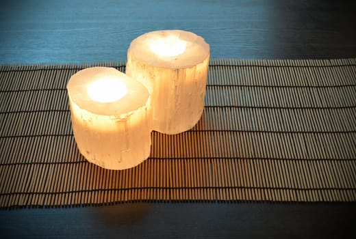 Pair of crystal candle holders, candles are lit. Peaceful atmosphere