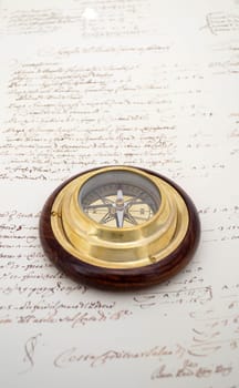Traditional brass and wood compass on old paper