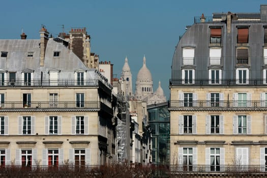 The "Sacre-Coeur"" basilica seen between two Haussman-style buildings"