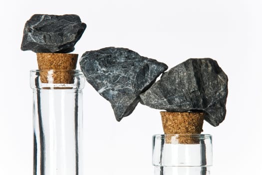 Stones in balance on glass bottles with corks