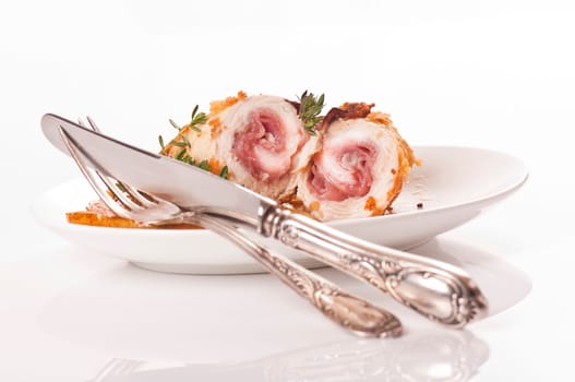 Schnitzel roll on porcelain plate with fried pears