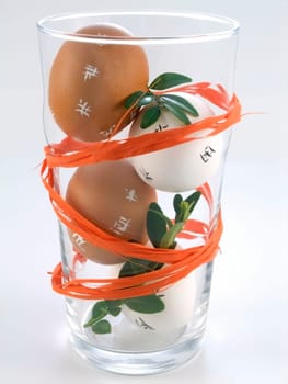 four Easter Eggs in a glass isolated on white background