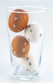 four Easter Eggs in a glass isolated on white background