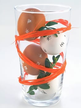 four Easter Eggs in a glass isolated on white background