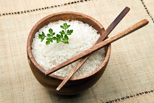 uncooked rice grains in wood bowl