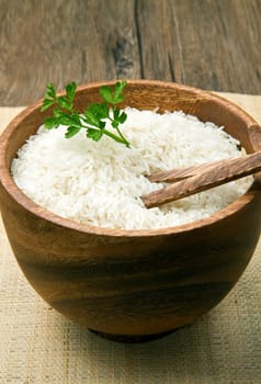 uncooked rice grains in wood bowl