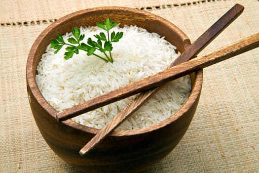 uncooked rice grains in wood bowl