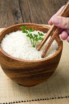 uncooked rice grains in wood bowl