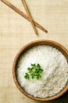 uncooked rice grains in wood bowl