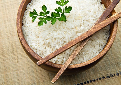 uncooked rice grains in wood bowl
