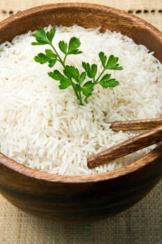 uncooked rice grains in wood bowl