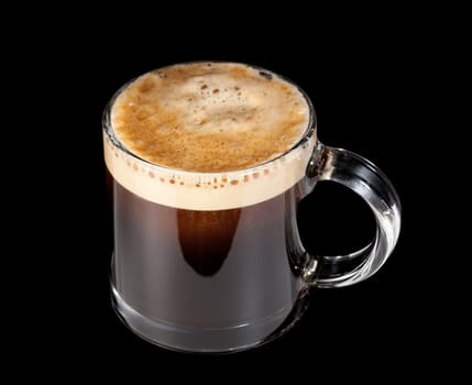 Black expresso coffee with heady froth in a glass mug or cup with path around the edge