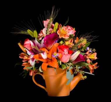 Bright and colorful bunch of flowers arranged in a watering can plant pot and isolated against black