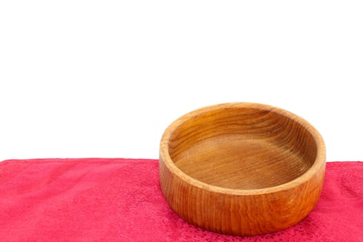 Empty teak wood bowl on a red placemat isolated naturally on a white background.