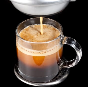 Black expresso coffee with heady froth in a glass mug or cup