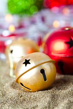 Close-up of golden and red jingle bell Christmas baubles with candles