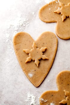 Making gingerbread cookies for Christmas. Gingerbread dough with heart shapes