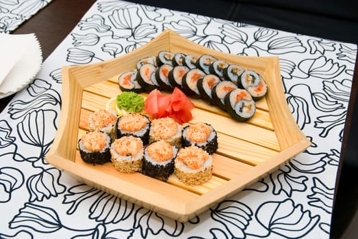 At restaurant: Set of sushi on wood plate.