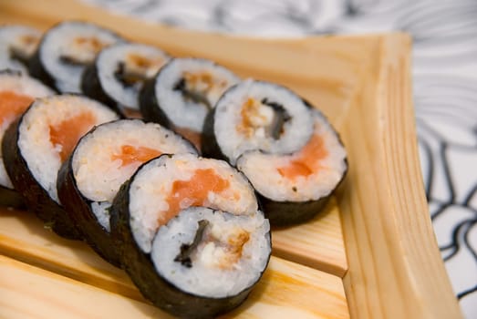Set of sushi on wood plate.