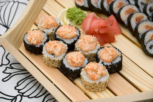 At restaurant: Set of sushi on wood plate.