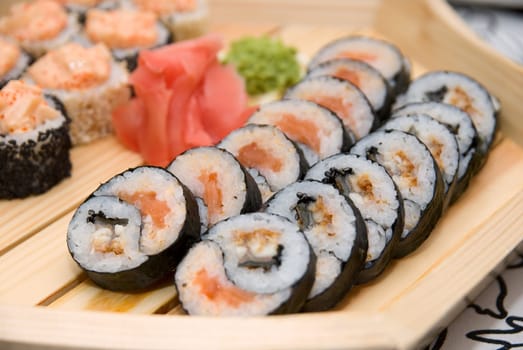 Set of sushi on wood plate.