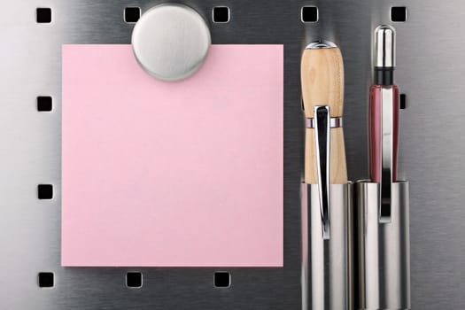 Sticky notes,pencil and pen with magnet on pin board.