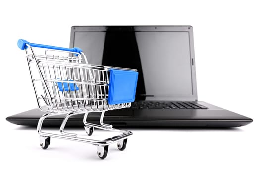 Small shopping cart in front of a notebook