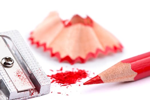 Sharpened red pencil with sharpener and shavings