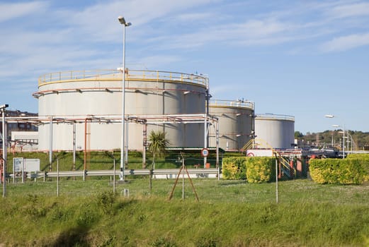 petrol tanks in an oil refinery over a blue sky