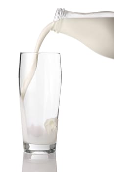 Milk from milk bottle poured into glass.