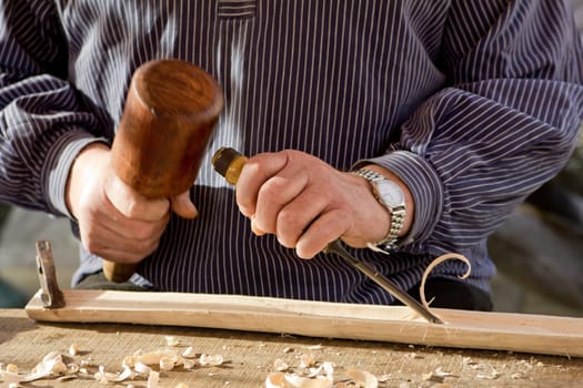 The woodcarver work in the workshop. Work of artist.