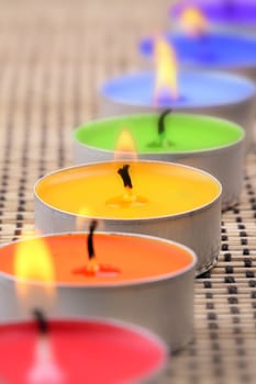 Tea lights in a row in rainbow colors.