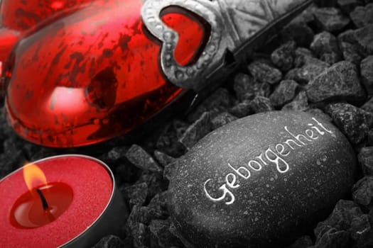 Still life with heart,inscribed stone and candle.