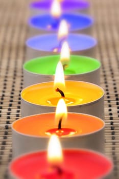 Tea lights in a row in rainbow colors.