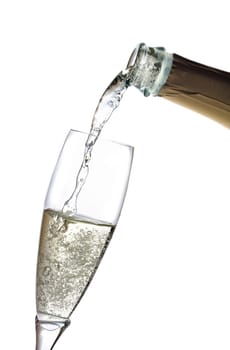 A glass of champagne is poured from a bottle.