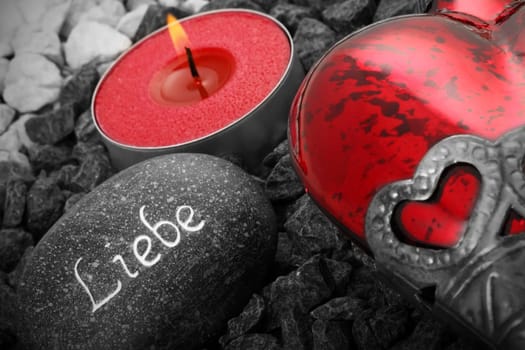 Still life with heart,inscribed stone and candle.