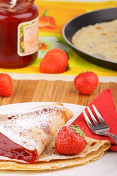 Fresh crepes with jam,powdered sugar and strawberries.