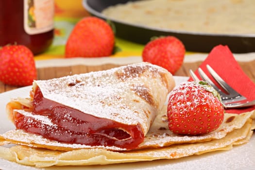 Fresh crepes with jam,powdered sugar and strawberries.