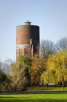 Park with old water tower in fall with colorful trees and blue sky