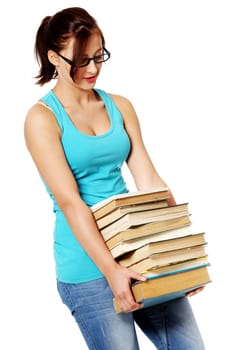 Young caucasian girl in glasses standing and holding many books. Isolated on white.