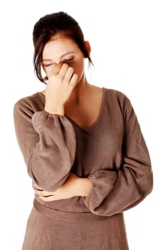 young woman having a headache and holding her nose in her hands.