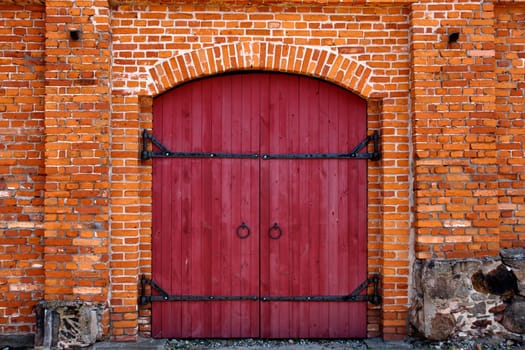 Old Red wooden door in red brick wall