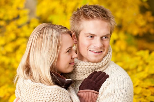 Embracing young couple in love in autumn park