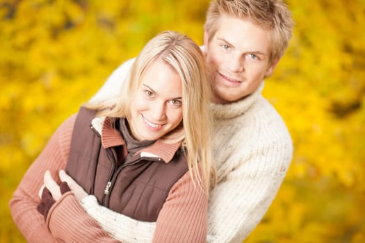Autumn smiling young couple in love hugging in park together