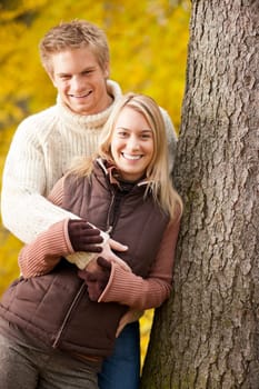 Smiling young couple in love hugging in autumn park together