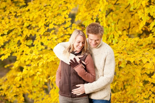 Autumn smiling young couple in love hugging in park together