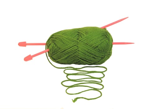 A green ball of wool with pink knitting needles poking through