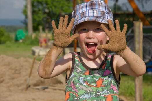 Boy playing in the garden with sandy hands