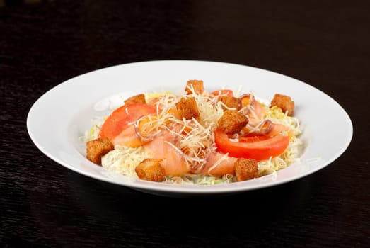 Salad of lettuce, chinese cabbage, tomato, garlic rusk, parmesan cheese, sauce and smoked salmon filet