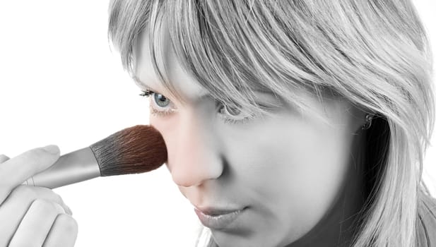 Girl with brush painting her face on white